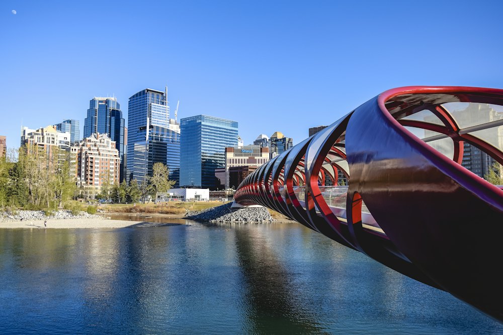 Calgary's red Peace Bridge over the Bow River with the skyline behind
