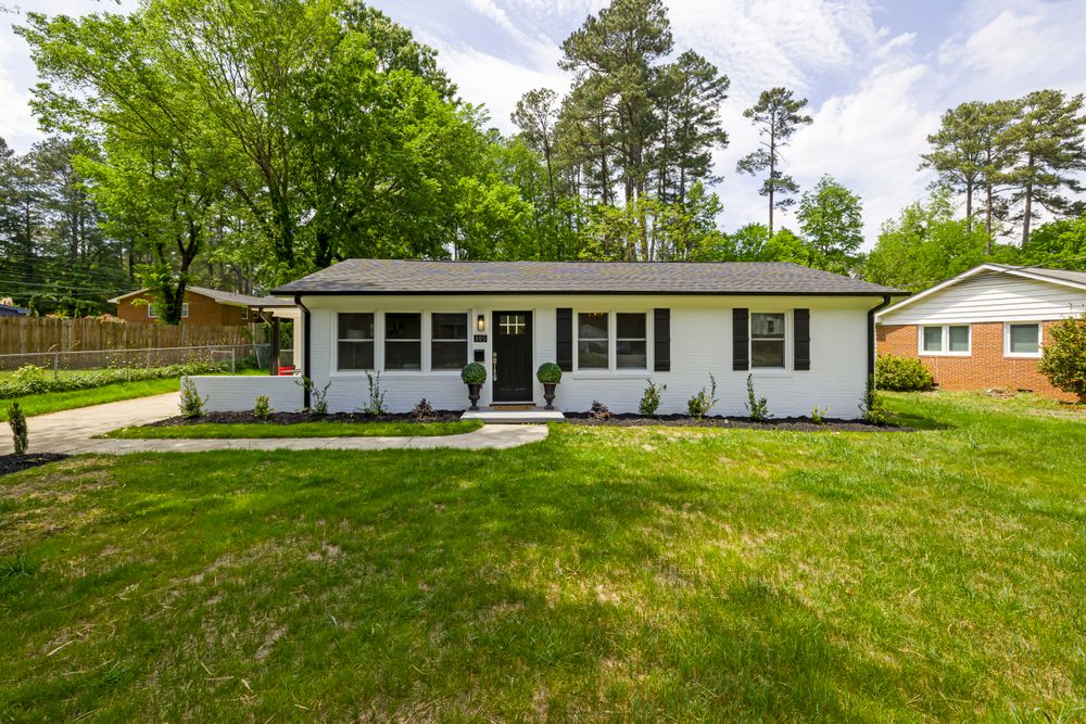 A small single-storey detached home with a green lawn